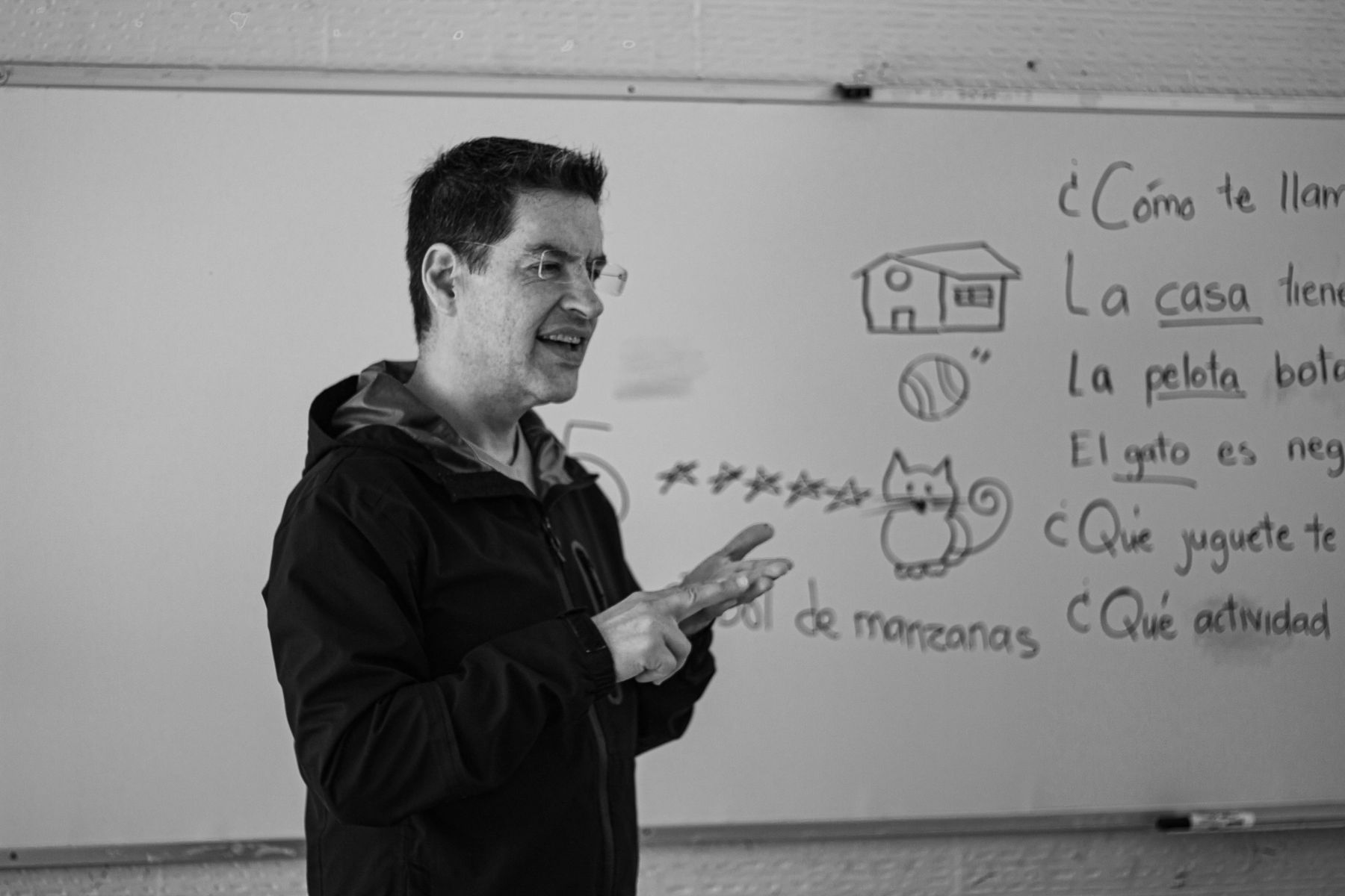 A mentor sketching an explanation on a whiteboard for a learner