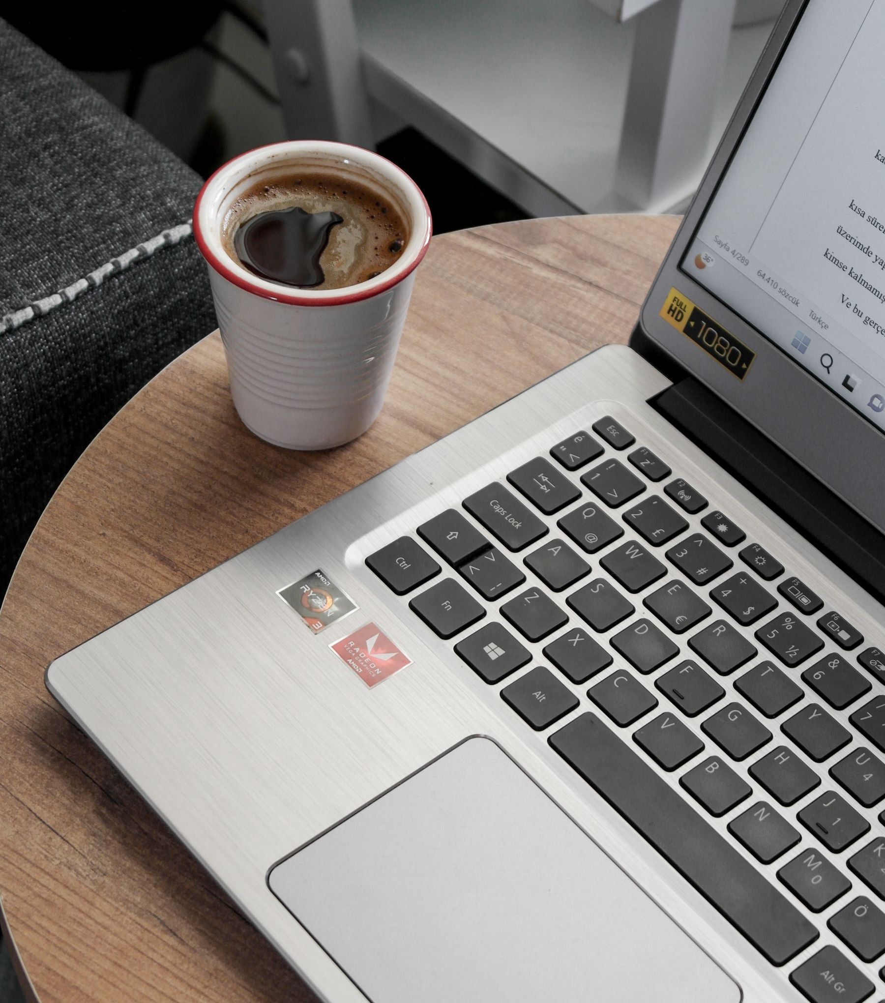A laptop and a cup of coffee on a wooden table