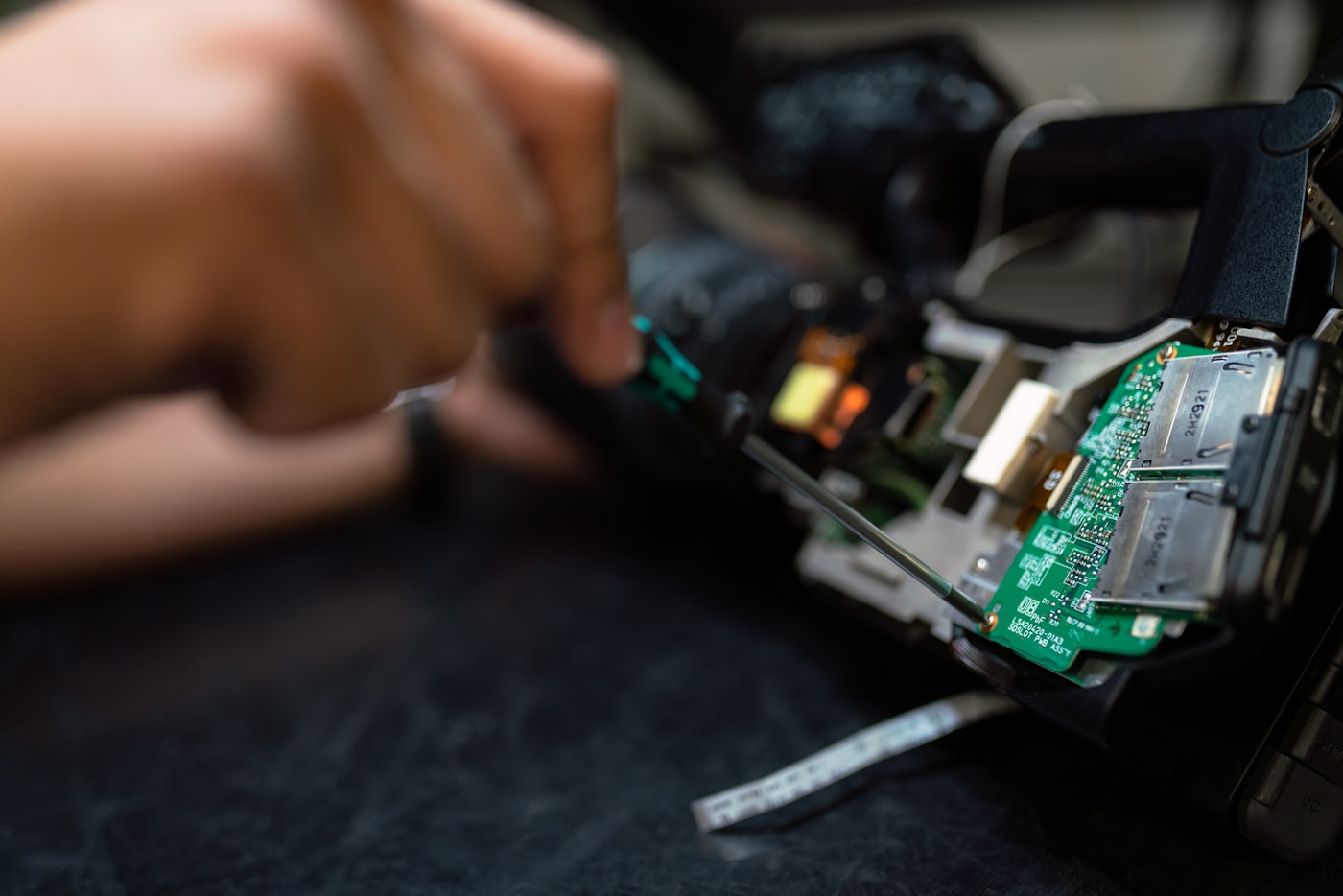 A technician repairing a laptop at a workbench